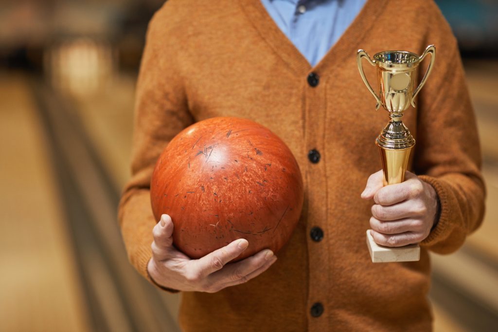 Bowling Player Holding Trophy and Ball