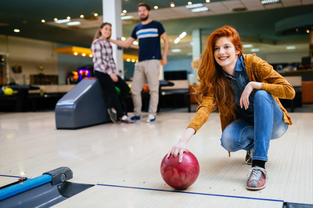 Beautiful woman bowling with friends