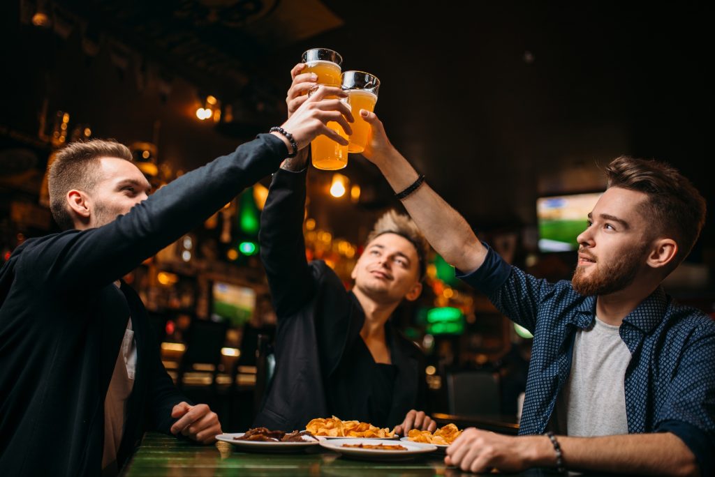 Fun company raised their glasses in a sport bar