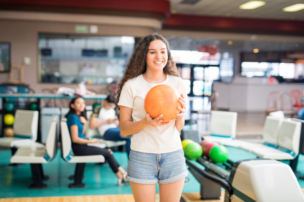 Girl Enjoying Recreational Bowling In Club