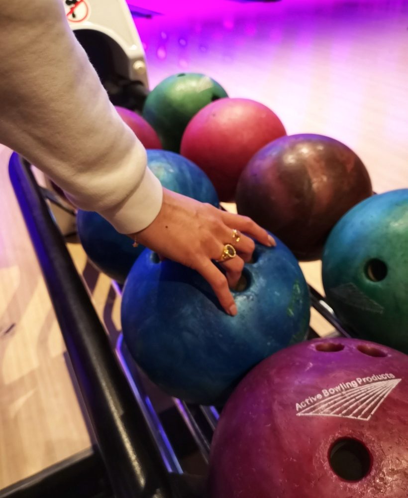 Grabbing a blue bowling ball to throw